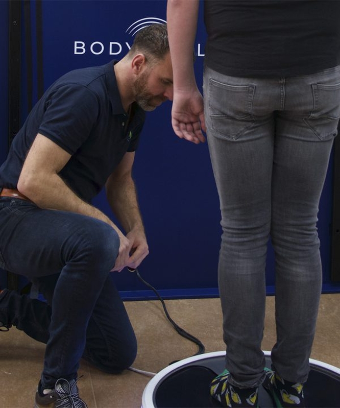 Vibratie en herstel - Abstracte figuur op platform met golvende lijnen die vibraties door het lichaam tonen.